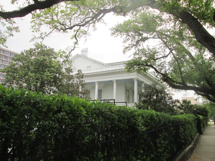 a very large house next to some trees and bushes