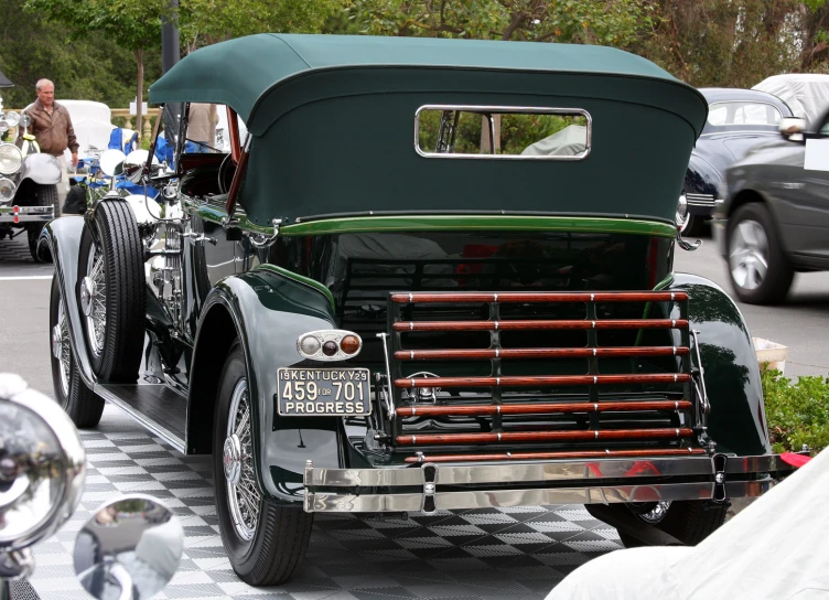 an old style green car is shown in the middle of a checkered pattern