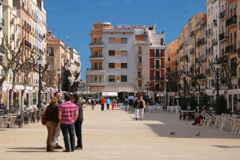 people stand near a street in a city