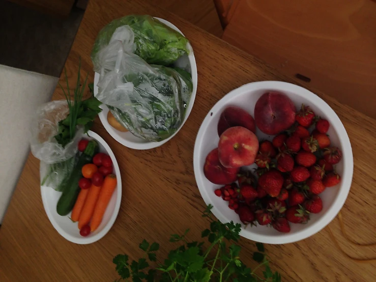 two white plates filled with vegetables and fruits