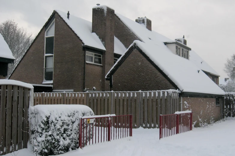 this is a po of a fence and a home covered in snow