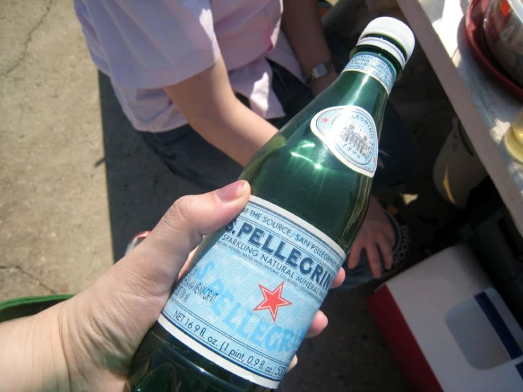 a person holding up a bottle filled with liquid