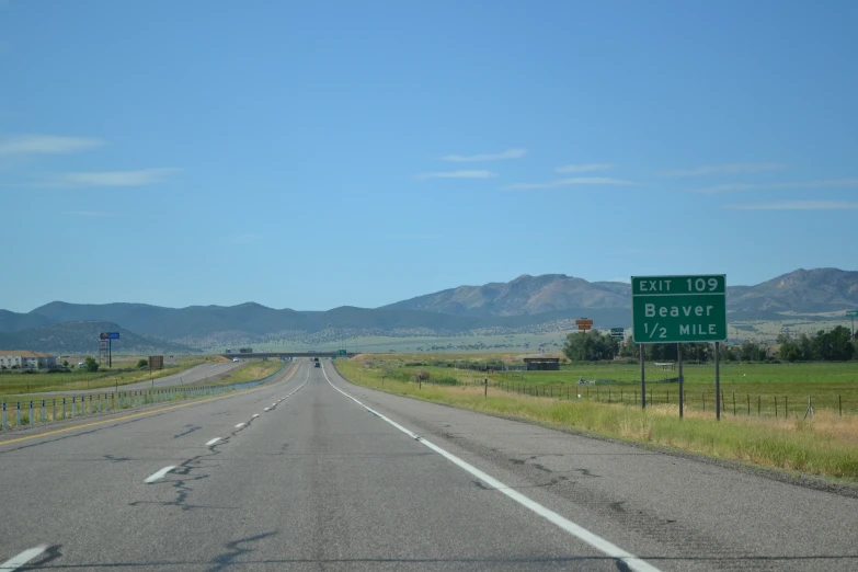 an interstate highway with two green street signs in front