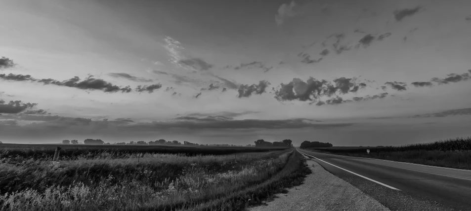 black and white image of long highway in the country