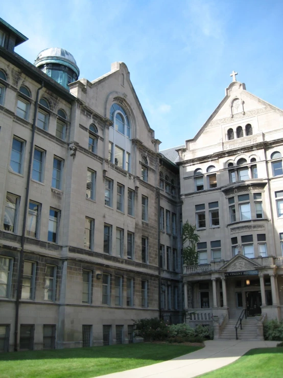 two historic buildings side by side one is in the middle of a lawn