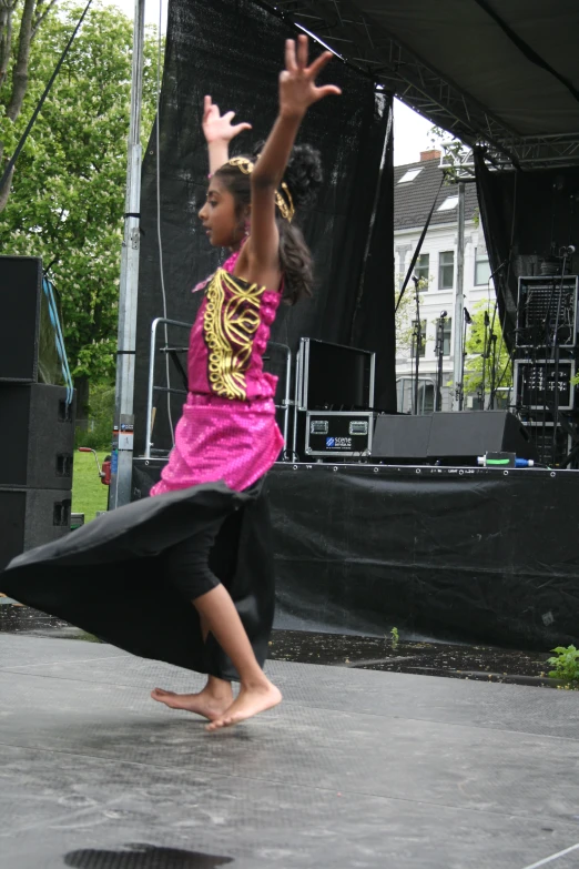 a woman in a black and pink dress dancing