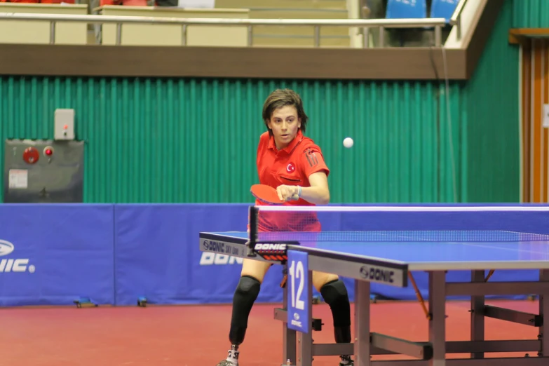 woman playing table tennis during match in indoor arena