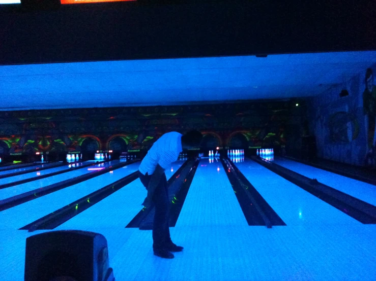 a man with an umbrella in front of bowling lanes