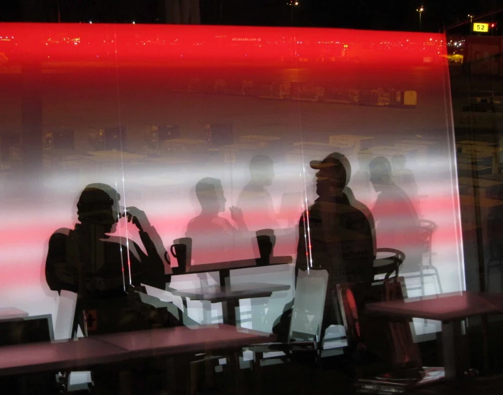 a reflection in the glass of a dining room with people sitting at tables