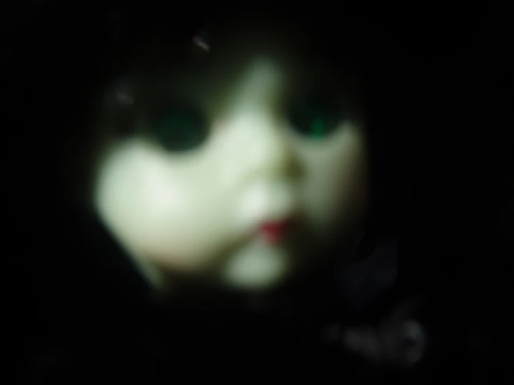 a blurry pograph of an evil looking doll