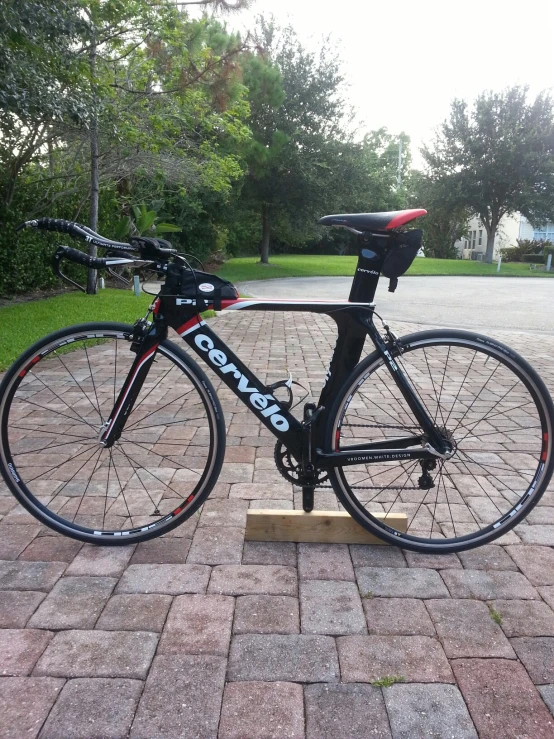 a bicycle parked in a driveway on a brick ground