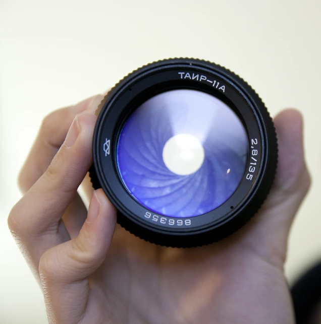 hand holding a blue lens up close to the camera