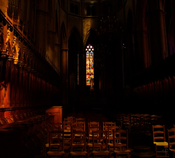 an empty room with chairs near a large stained window