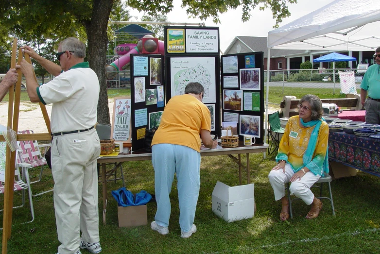 an old man is standing next to a woman at a table