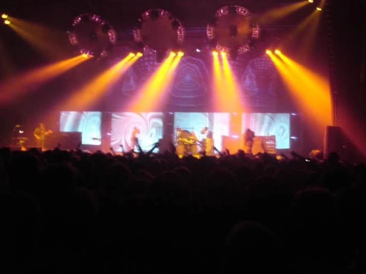 several stage lights illuminate a stage set with stage chairs