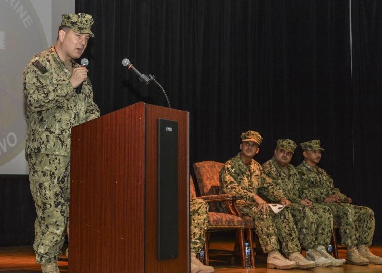 a military personnel speaking at the podium