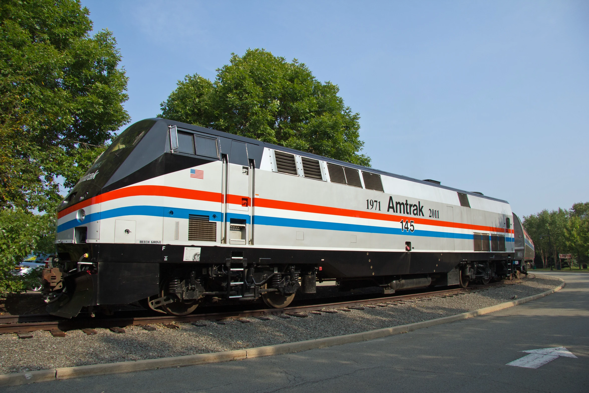 a large white and red train traveling down tracks