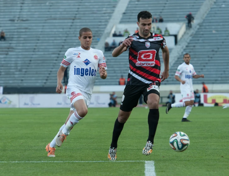 soccer players are playing soccer in an empty stadium