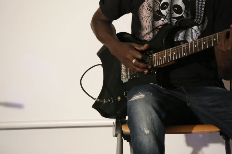 a man that is sitting in a chair with a guitar