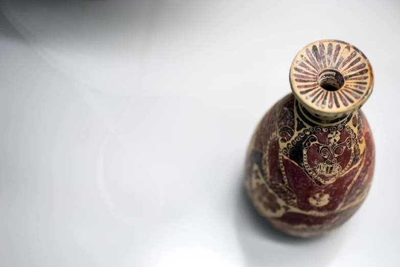 a small brown vase sitting on top of a white table