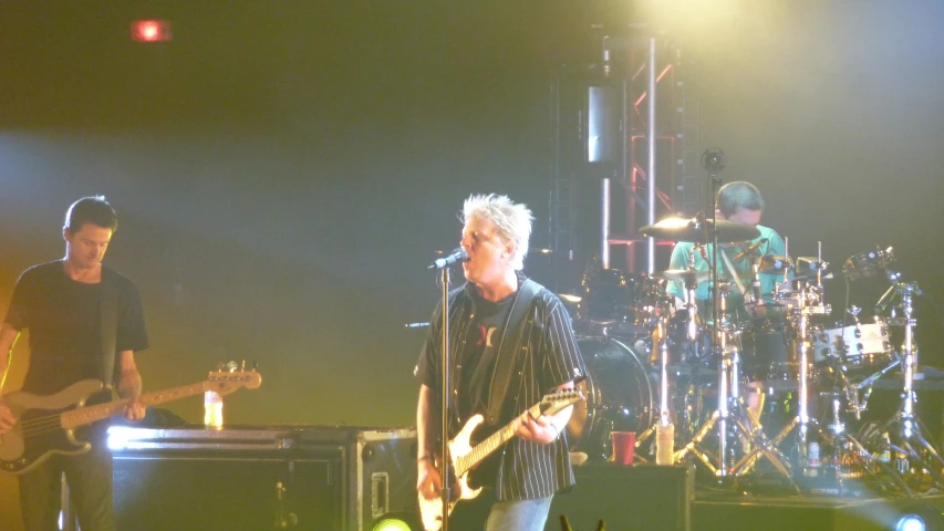 a group of people that are standing up with guitars