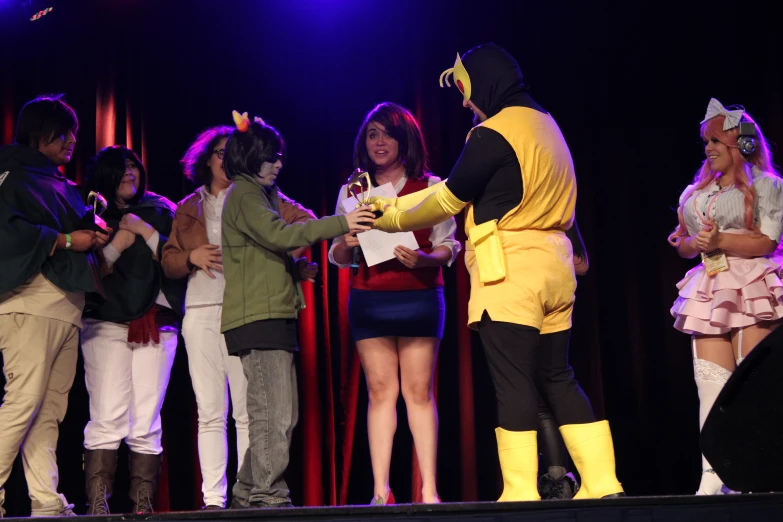 people dressed in costume standing on stage and receiving soing