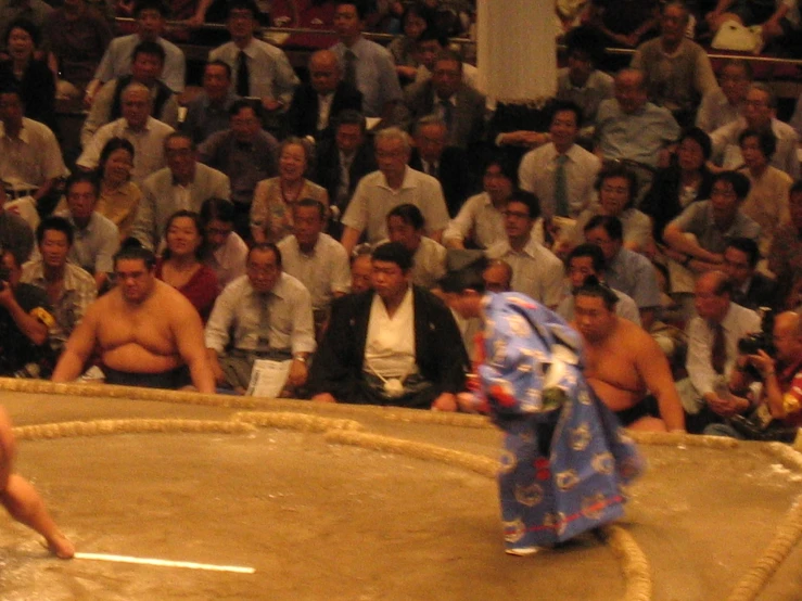 wrestlers playing a game in an arena with a crowd