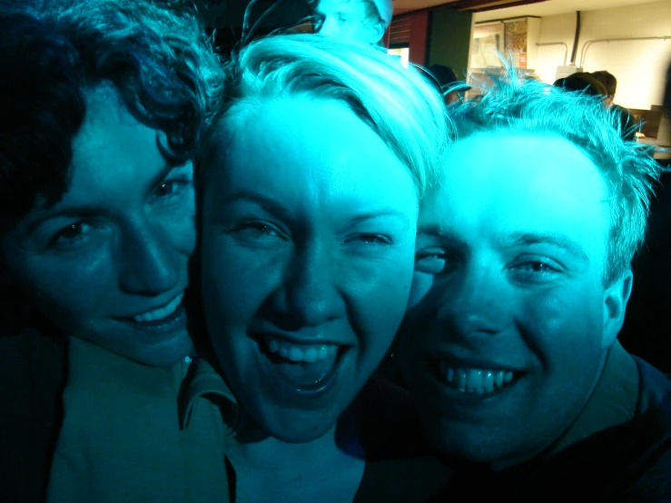 three people pose for the camera in a group