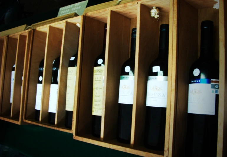 many bottles of wine sit in an open shelf