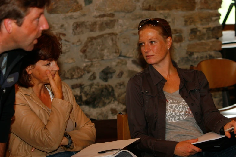 three people sitting next to each other in chairs