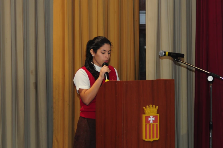 a woman standing at a podium giving a presentation