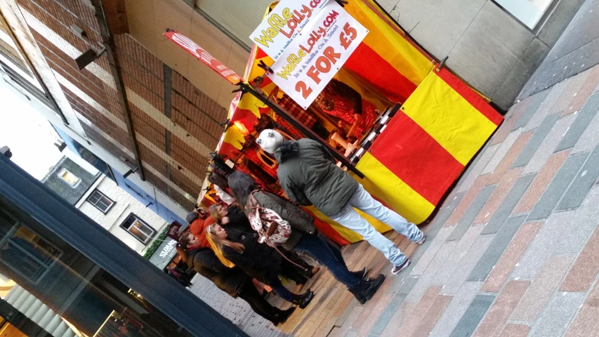 people standing in front of colorful red and yellow stand