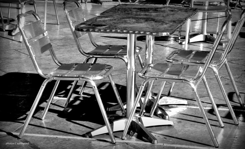 a set of four table and chairs with one chair facing back