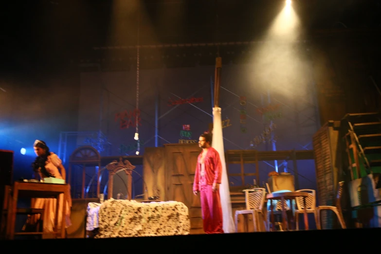 stage scene with a man and woman standing on wooden platforms