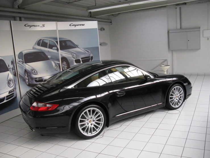 a black sports car parked in front of an advertit