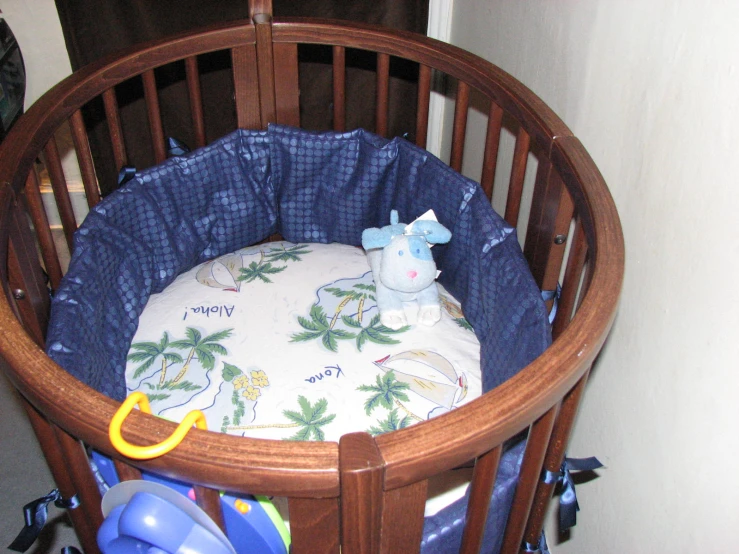 a baby crib that has a bed with an elephant on it
