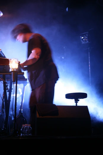 a man standing next to a keyboard on a stage