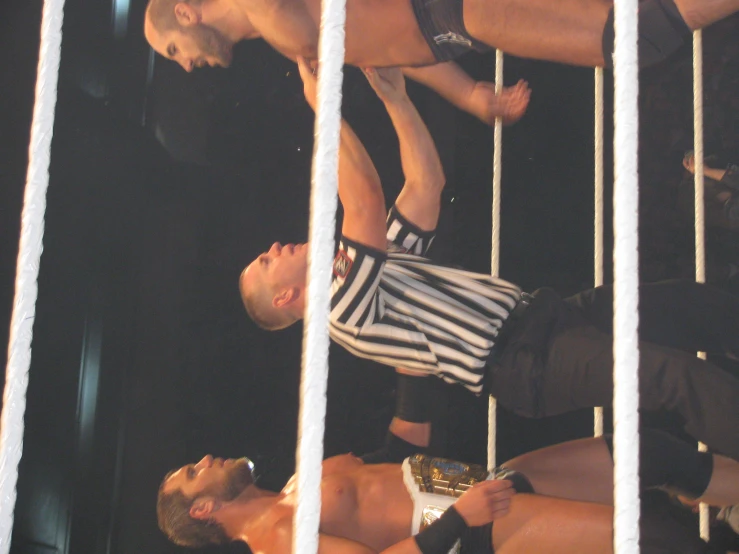 two men on wrestling team one pointing to the referee