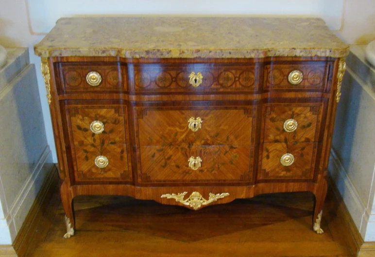 antique dresser with carved wood drawers and gold decor