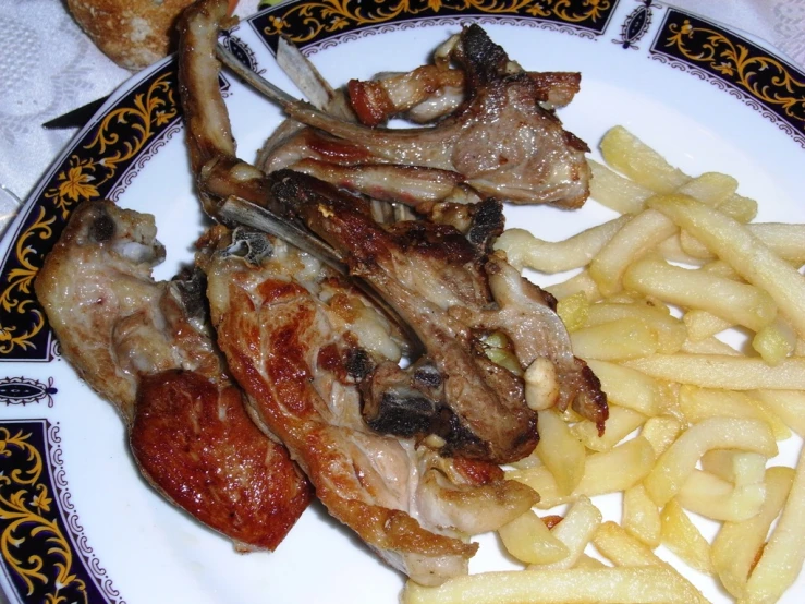 some meat is sitting on a plate with fries and cheese