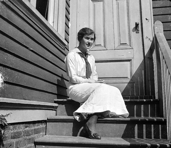 the woman smiles while sitting on a step