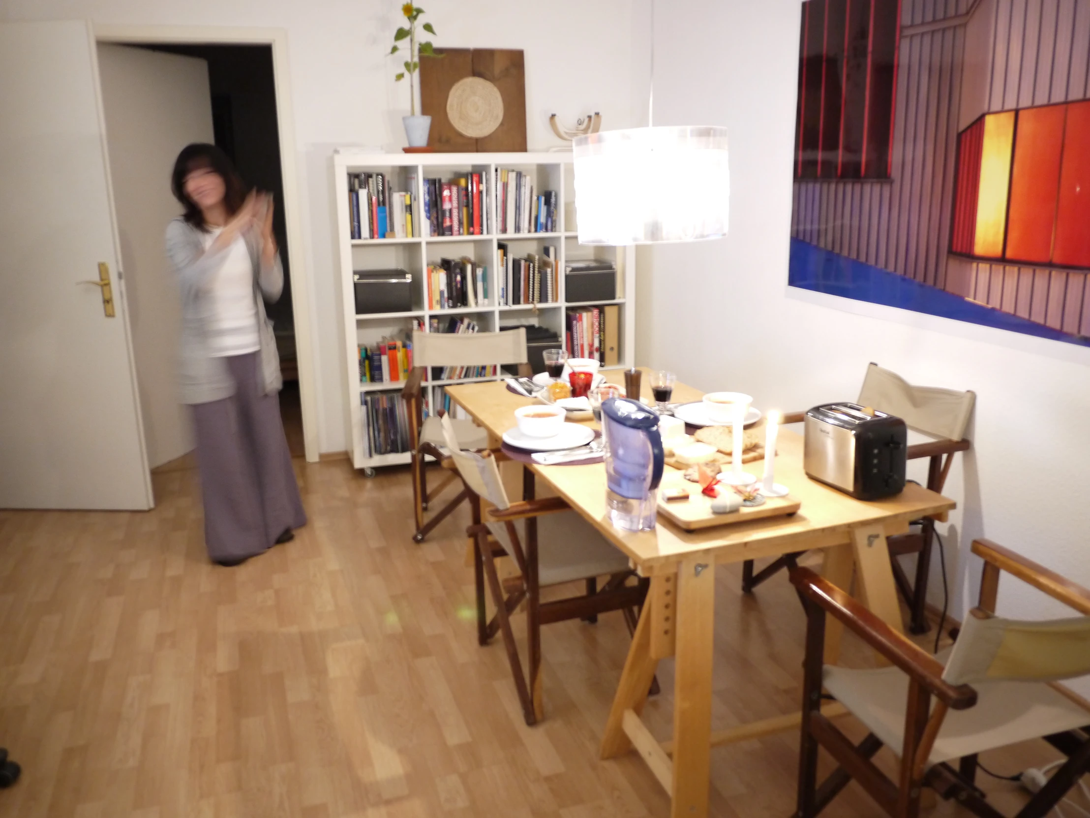 a woman walking into the door behind the dinner table