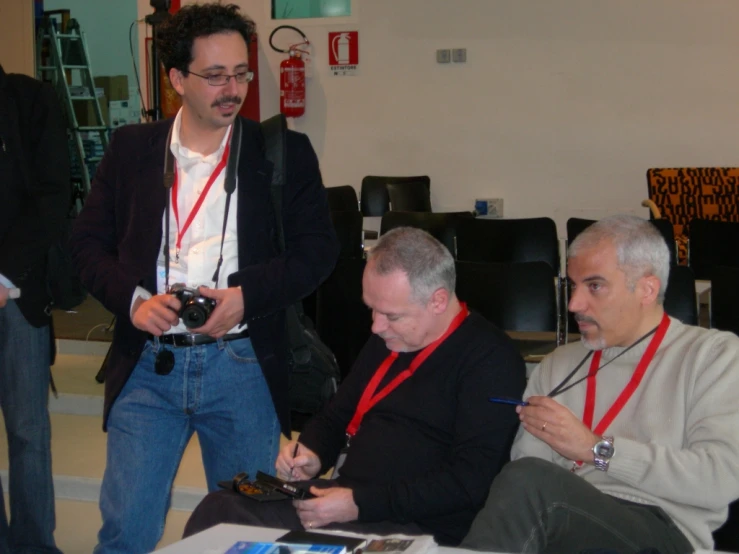 men sit around a table at a conference and observe soing