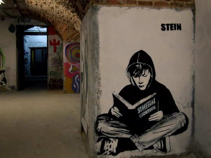 a person reads a book painted on a wall