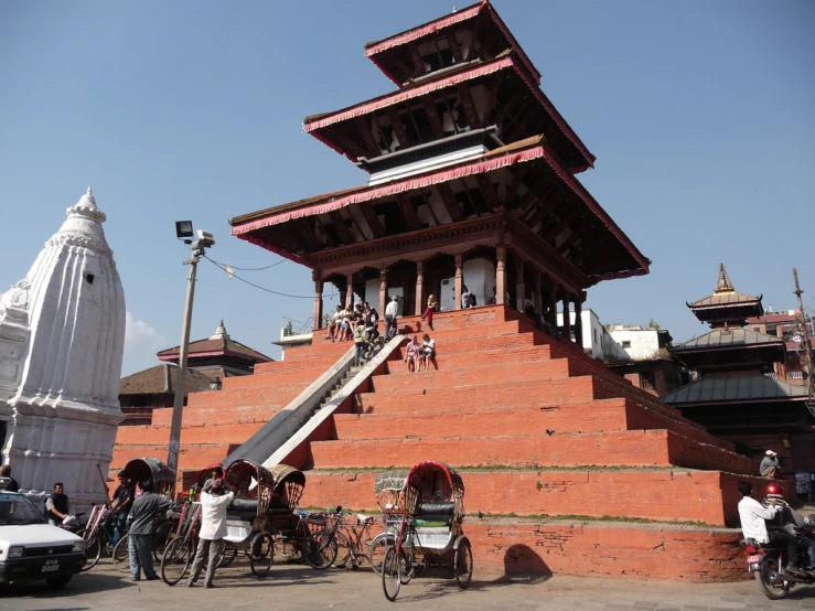 a building with people on the top and bikes parked in front