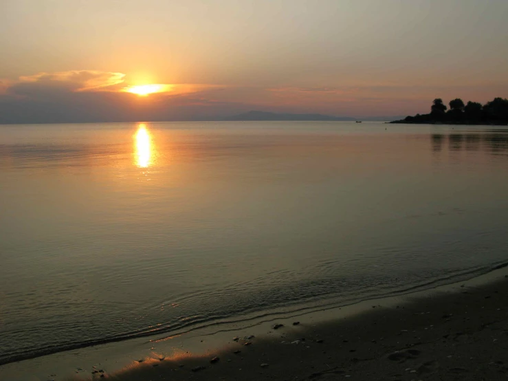 a lone boat in the water at sunrise