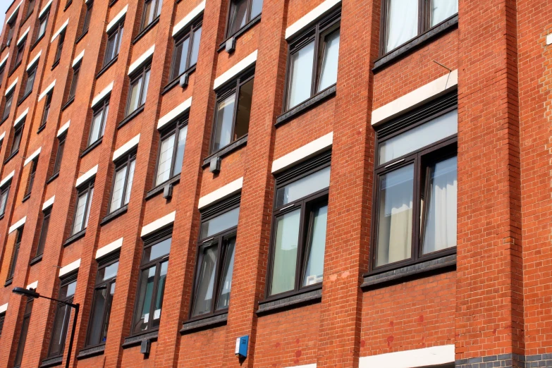 two buildings side by side with windows, street sign and one light