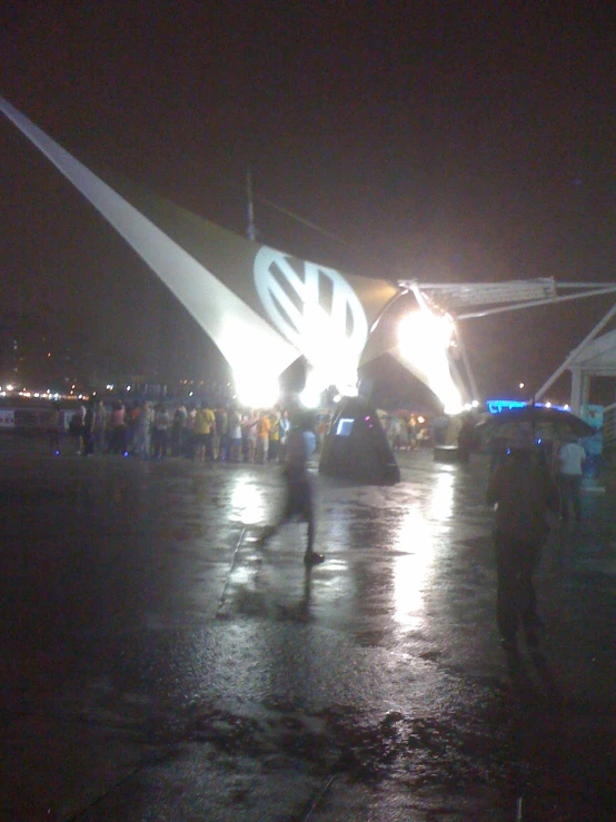 people walking in the rain and under the lights of the arch