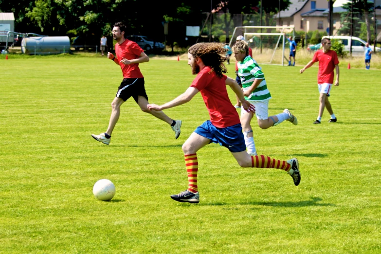 four young men playing soccer in the grass