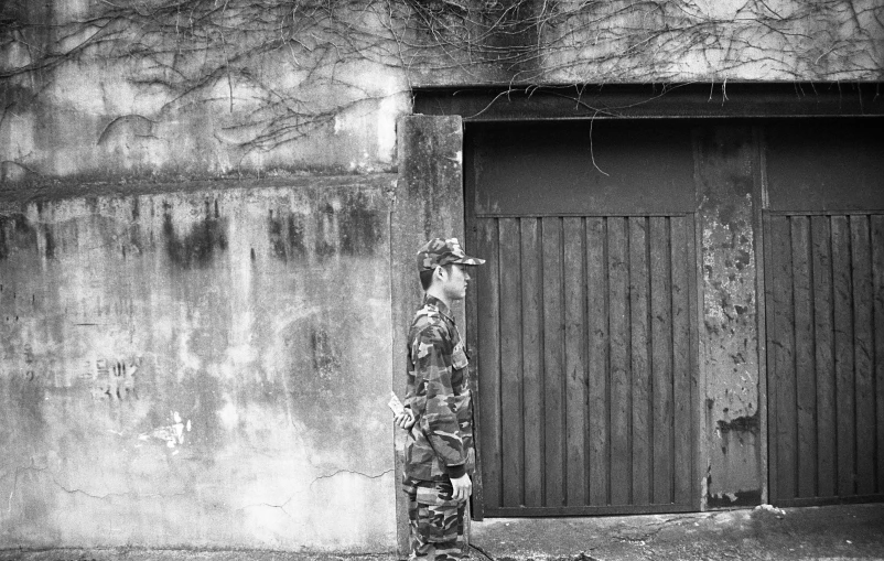 a man with skateboard looking over the door to a dark city